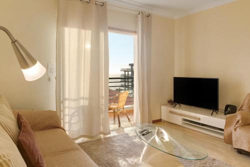 a living room with a couch and a television at Oliveira Atlantic View in Funchal
