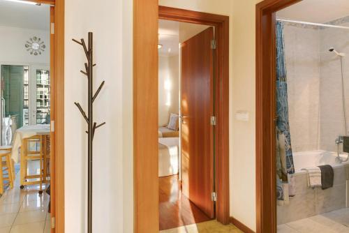 a bathroom with a glass door leading to a bathroom with a tub at Oliveira Atlantic View in Funchal