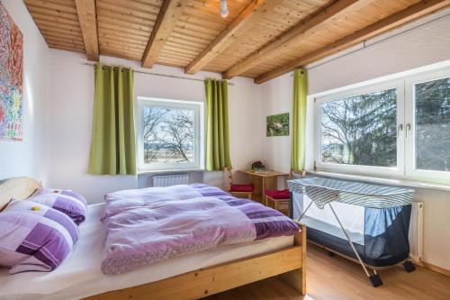 a bedroom with a large bed and two windows at Das kleine Paradies in Pürgen
