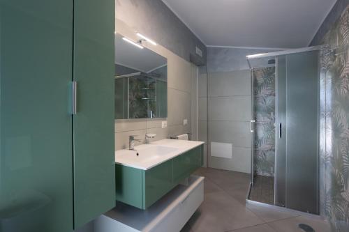 a bathroom with a sink and a glass shower at La Casa Vacanza Dei Sogni in Paestum