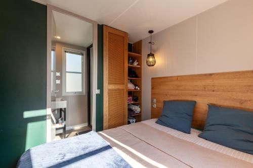 a bedroom with a bed with blue pillows at Camping Lou Soulei 218 in Carry-le-Rouet