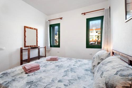 a bedroom with a bed and a mirror and windows at Casa Laly in Callao Salvaje