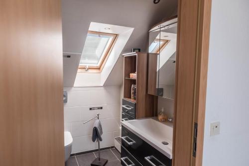a bathroom with a sink and a toilet and a window at Haus Jäschke in Bremerhaven