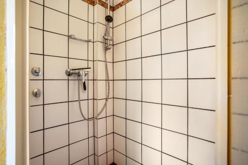 ein Badezimmer mit Dusche und weiß gefliesten Wänden in der Unterkunft Apartment Sonnengärtchen in Blankenburg