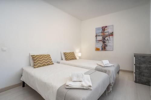 two beds in a room with white walls at Casa Terrace Carvoeiro in Carvoeiro