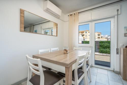 a dining room with a wooden table and white chairs at Casa Terrace Carvoeiro in Carvoeiro