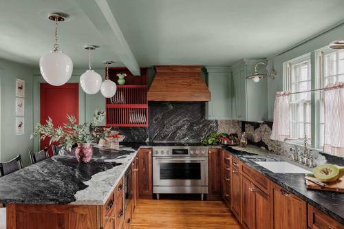 a kitchen with black marble counter tops and wooden cabinets at Historic Island Home Heated Pool in Nantucket