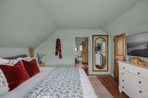 a bedroom with a large bed with red pillows at Historic Island Home Heated Pool in Nantucket