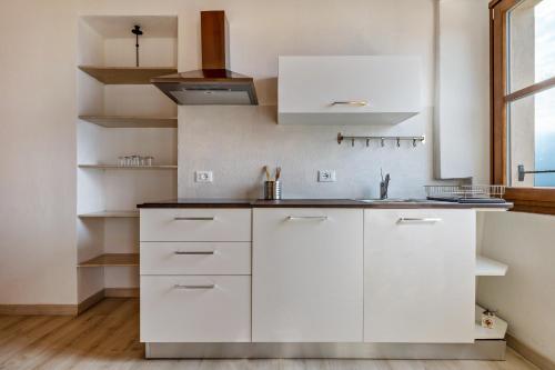 a kitchen with white cabinets and a sink at Nonna Gina in Tignale