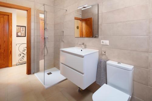 a bathroom with a toilet and a sink and a shower at Villa ju-mi in El Cerro