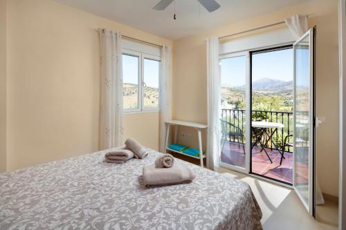 a bedroom with a bed and a balcony with a view at Villa ju-mi in El Cerro