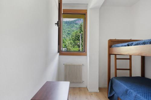 a room with a window and a bed and a table at Marilleva 900 Terminal in Mezzana