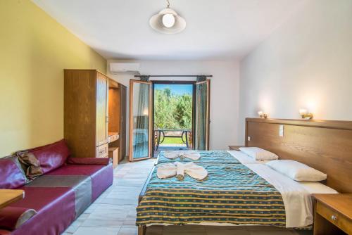 a hotel room with a bed and a couch at Mirage Arillas Studio Type C16 in Arillas