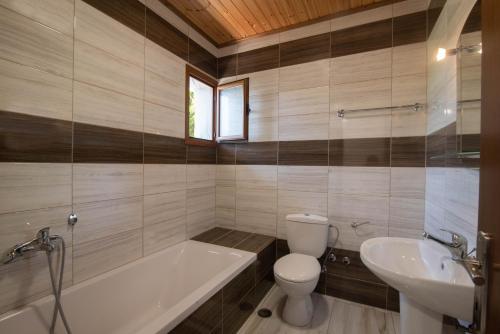 a bathroom with a tub and a toilet and a sink at Mirage Arillas Studio Type C16 in Arillas