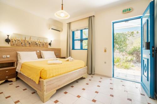 a bedroom with a bed and a large window at Livadia Beach Suite in Tílos