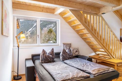 a living room with a couch and a staircase at Apartment Alte Mühle in Scharnitz