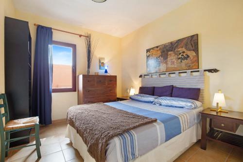 a bedroom with a bed and a dresser and a window at La Palmera de la Oliva in La Oliva