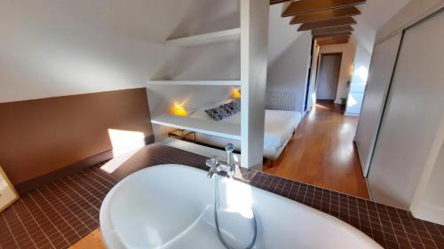 a bathroom with a sink and a bed in a room at La maison jaune - 3ch - 6pers in Loctudy
