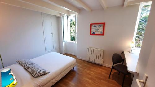 a small bedroom with a bed and a window at La maison jaune - 3ch - 6pers in Loctudy