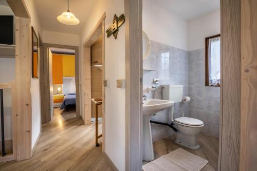 a bathroom with a white toilet and a sink at Casa Camilla in Ledro