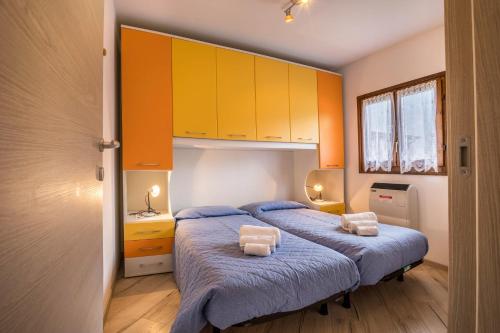 a bedroom with two beds and orange cabinets at Casa Camilla in Ledro