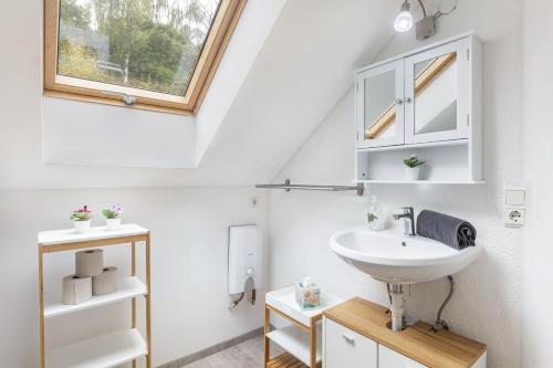 a bathroom with a sink and a window at Ferienhaus Enztal in Zweifelscheid