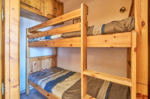 a bedroom with two bunk beds in a cabin at Studio Alpe d'huez in LʼHuez