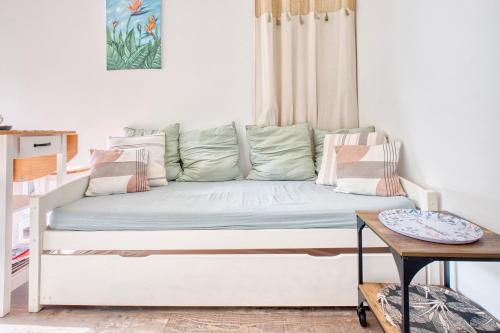 a white couch in a room with a table at Gite L'oiseau Du Paradis in Ribérac