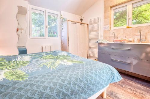 a bedroom with a blue bed and a sink at Gite L'oiseau Du Paradis in Ribérac