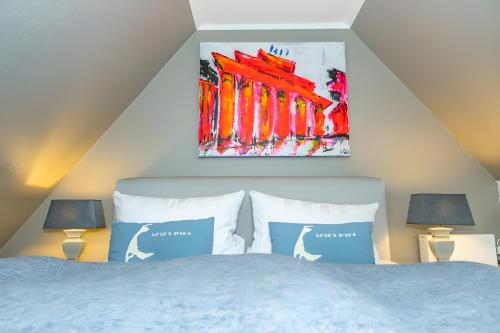 a bedroom with a bed with two lamps and a painting at Tolle Wohnung mit Sonnenbalkon in Wenningstedt