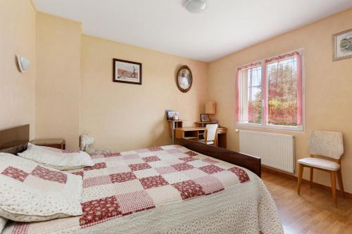 a bedroom with a bed and a desk and a window at Chambre d'hôtes à Saint-Molf in Saint-Molf