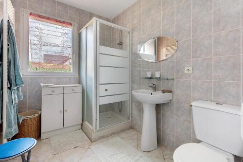 a bathroom with a toilet and a sink and a mirror at Chambre d'hôtes à Saint-Molf in Saint-Molf