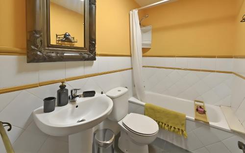 a bathroom with a white toilet and a sink at Puente del Narcea 3 in Cibuyo