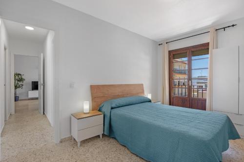 a white bedroom with a bed and a window at Chipiona Centro y Playa in Chipiona