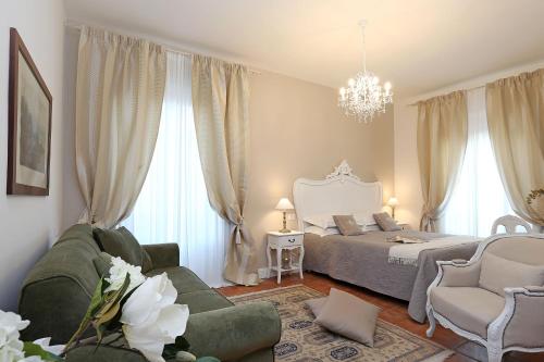 a bedroom with a bed and a couch and chairs at Casa Ponte Sisto Guesthouse in Rome