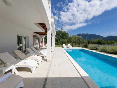 a villa with a swimming pool and lounge chairs at Villa Olivia by Interhome in Šestanovac
