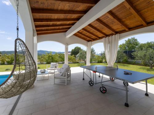 an outdoor patio with a ping pong table and a swing at Villa Olivia by Interhome in Šestanovac