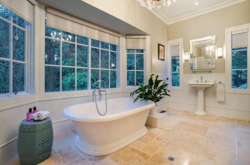 a bathroom with a tub and a sink and windows at Moulton Park Estate - Homestead in Sassafras