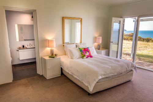 a bedroom with a bed with a view of the ocean at Antechamber Bay Retreats in Penneshaw