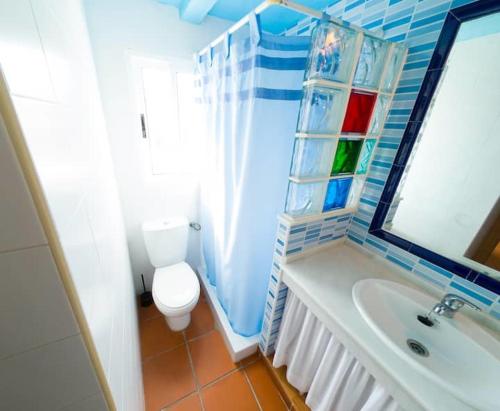 a bathroom with a toilet and a sink and a mirror at Casas Pepe 6 Bungalow in Los Caños de Meca