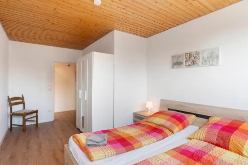 two beds in a bedroom with a wooden ceiling at Gästehaus Vogel in Horumersiel