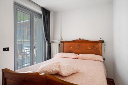 a bedroom with a bed with a large window at Ciclamino Standard Vittoria in San Lorenzo in Banale