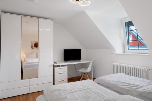 a bedroom with two beds and a desk with a television at Ferienwohnung Alte Münz in Müllheim
