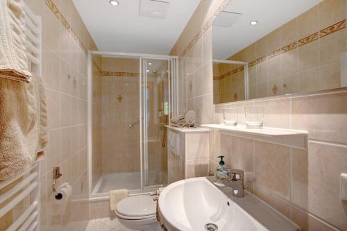 a bathroom with a toilet and a shower and a sink at Seeberg - Haus Annamirl in Bayrischzell