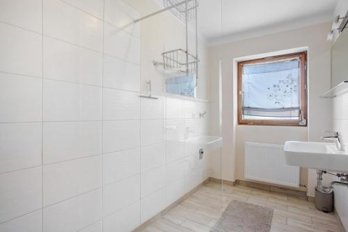 a white bathroom with a shower and a sink at Wohnung Hochstaufen in Inzell