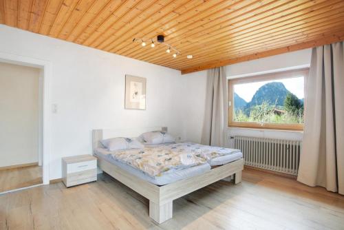 a bedroom with a bed and a window at Wohnung Hochstaufen in Inzell