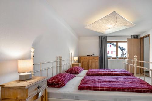 a bedroom with a large bed with red sheets at Ferienwohnung Silvia in Roßhaupten