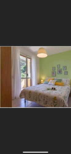 a bedroom with a bed with a white bedspread and a window at Casa Vacanza Sa Petra Ruja B in Siniscola