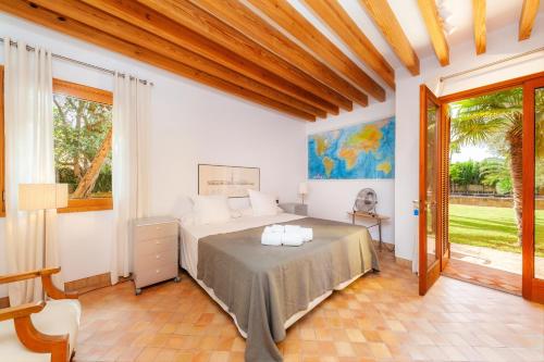 a bedroom with a bed and a large window at Villa Cala Bona in Cala Bona