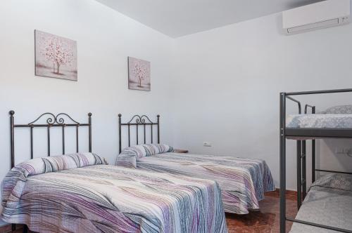 two beds sitting next to each other in a bedroom at Sunset El Tejar in Almogía